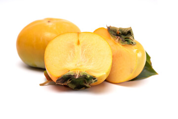 Whole and cut in half of persimmon with leaves isolated on white background.