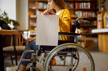 Disabled student in wheelchair holds paper sheet