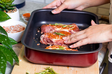 Raw marbled beef steak slices with salt and spices on metal baking dish for oven background. The preparation of a fresh meat for dinner.