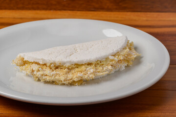 Tapioca on white plate on wooden table. Brazilian food.
