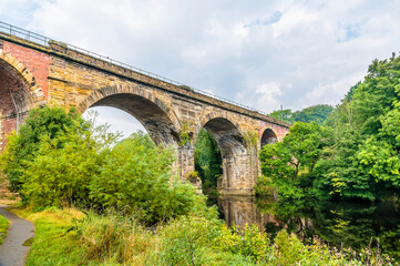 A view from the banks of the River Tees towards the Yarm Viaduct at Yarm, Yorkshire, UK in summertime