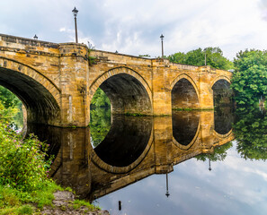 Reflections of the Yarm Road Bridge over the River Tees at Yarm, Yorkshire, UK in summertime