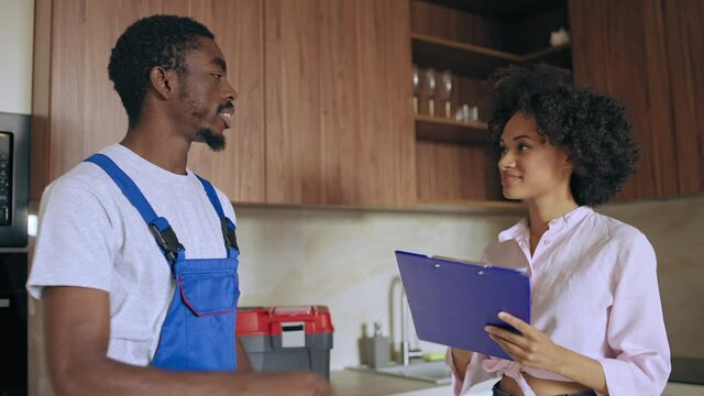 African-american worker and customer signing guarantee papers on repair services