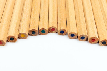 Many different colored pencils.Color pencils in arrange in color wheel colors on white background.Copy space.