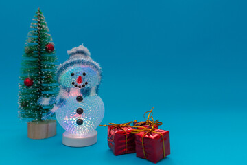 Glowing snowman, presents and Christmas tree with copy space.new year celebration.