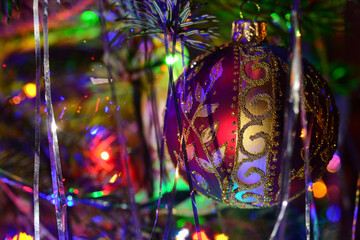 Big purple glass ball on Christmas tree. Merry xmas and Happy New Year closeup background.