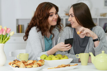 Obraz na płótnie Canvas Portrait of two female friends looking at smartphone