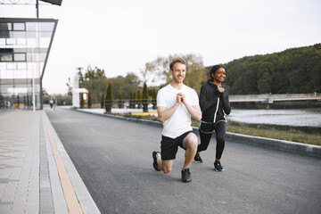 African-american woman and caucasian man training at the stadium