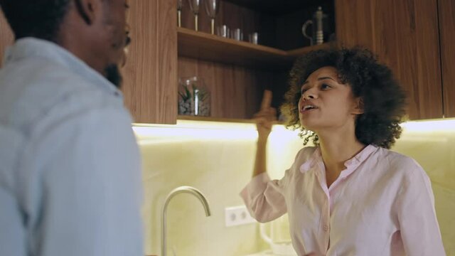 Unhappy couple fighting in kitchen, wife accusing husband, abusive relationship