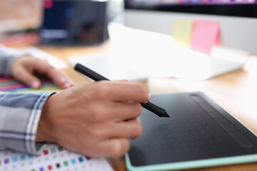 Female hand with stylus on graphics tablet closeup