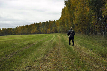 Fototapeta na wymiar man walking along the field