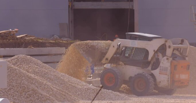 Excavation at a construction site, mini loader bobcat transports crushed stone to different construction places, where it is advisable to use compact construction equipment