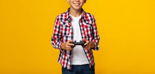 Cropped smiling european teenage boy with joystick playing online game