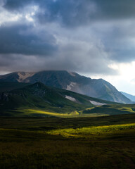 Beautiful photography of the mountain Oshten. Dramatic sky in the background and sun rays. Idea of tourism and hiking, breathtaking nature. High mountain in Russia.