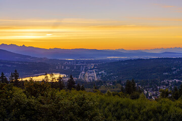 Golden sunrise over Fraser Valley reflected in Burrard Inlet at Port Moody, BC