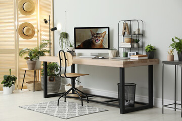 Comfortable workplace with computer in light room. Interior design