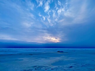 Fototapeta na wymiar winter landscape in blue, the sun appears through the clouds