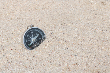 Classic navigation compass on beach as symbol of tourism with compass, travel with compass and...
