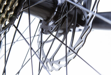 Bicycle disc brakes close-up, spokes. Light background transmission