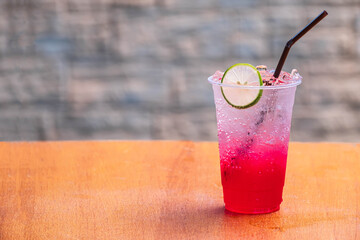 The red juice, soda Red water-lemon soda whit lemon slide on wood table and blurred background