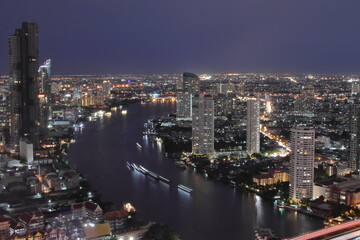 Fototapeta premium The Cityscape, the Skyscraper and the Chao Phraya River of Bangkok Thailand in the Night