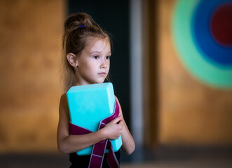 Portrait of serious girl gymnast with blockes on training in gym