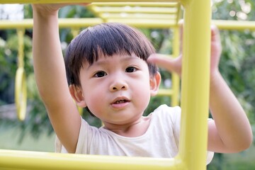 Little asian boy looking at camera on playground