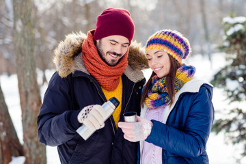 Portrait of cheerful guy pouring hot tea charming positive lady hold cup spend free time weekend outdoors