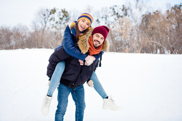 Portrait of cheerful glad man hold on back positive adorable girl toothy smile look camera have good mood outdoors