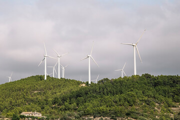 Windmills In Field Against Cloudy Sky