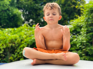 Young boy meditating outdoors on a sunny day