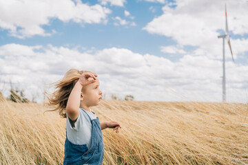 Toddler boy in wind farm field