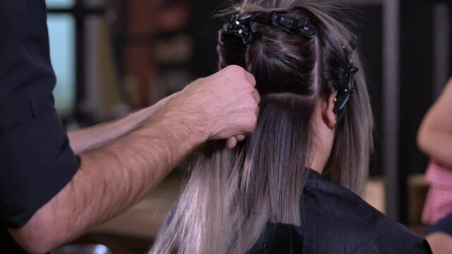 Hair extension installation in a salon by a hairdresser