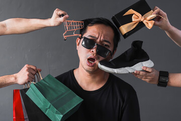 Funny online shopping sales promotion with silly expression shopaholic man surrounded by shopping...