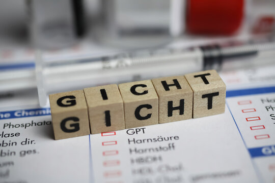 Viersen, Germany - June 1. 2021: Closeup of german word Gicht on laboratory requisition slip with syringe and vial