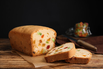 Delicious cake with candied fruits on wooden table