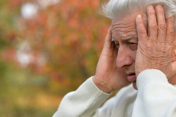 Fototapeta premium Close up portrait of thoughtful senior man outdoors