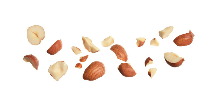 Pieces of tasty hazelnuts on white background