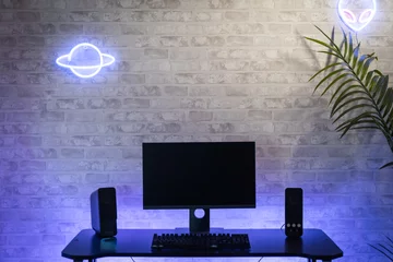 Fotobehang Gaming Computer gamer workspace with black screen monitor with neons and colorful lights. Gamer Rig.  © deliris