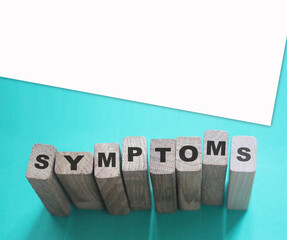 Symptoms word from wooden blocks with letters, viral diseases prevention and healing concept, blue...