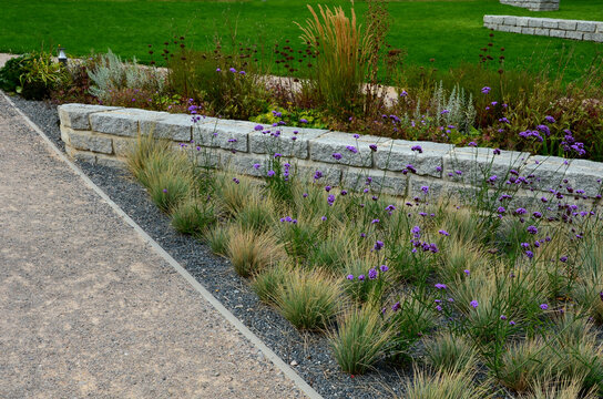 Granite walls made of stone blocks serve as design elements, retaining walls, or seating areas, seats for park visitors. parking for bicycles with metal frames and benches made of horizontal wires