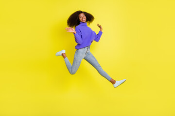 Fototapeta na wymiar Full length profile photo of charming dark skin person jumping running raise hands palms isolated on yellow color background