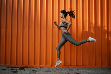 Beautiful athlete woman in sportswear. Young woman training outdoors