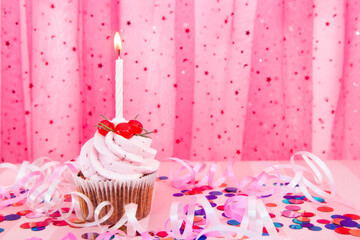 Pink cupcake and white one candle on colorful background with decorations and copy space , happy birthday and anniversary card - obrazy, fototapety, plakaty