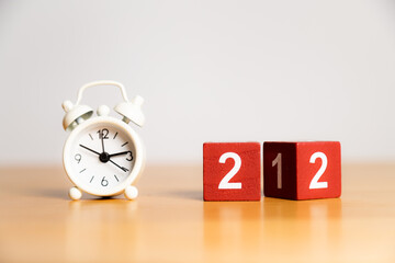 New Year 2022 - changing 21 cube. White little clock on a wooden table