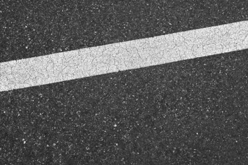Fototapeta premium Surface grunge rough of asphalt, Seamless tarmac dark grey with white line on the road and small rock, Texture Background, Top view