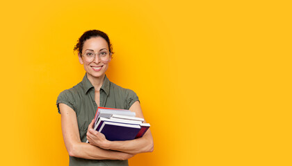 Young student woman smiling holding books and wearing - obrazy, fototapety, plakaty