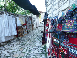 Historical street of Berat, Albania and colorful textile souvenirs 