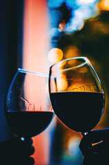 Young women hands holding glasses of red wine and clinking wine glasses in cafe or restaurant