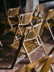 Set of wicker chairs arranged in rows to celebrate a ceremony.